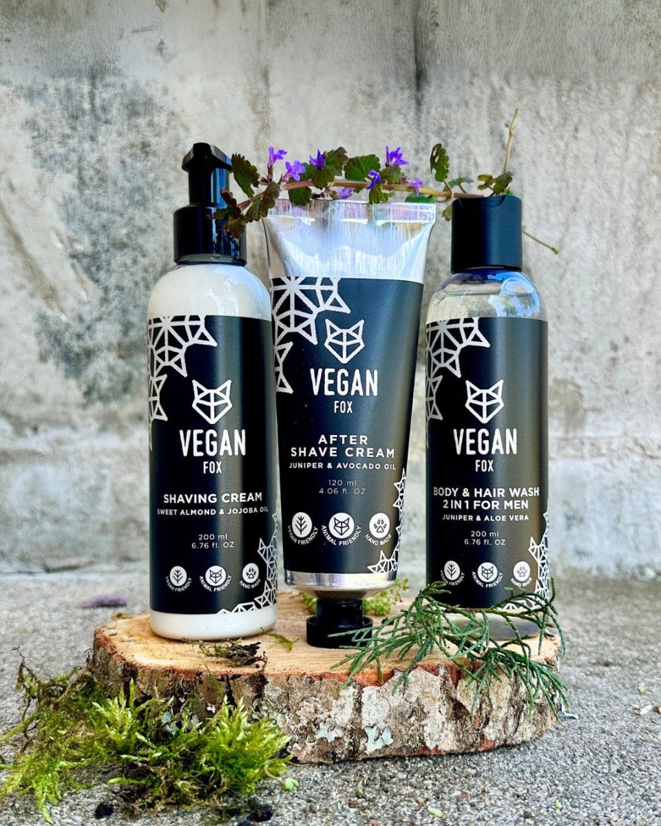 Vegan Fox hudvårdsset med tre svarta flaskor - rakningskräm, aftershave och body wash - på träbit med gröna växter